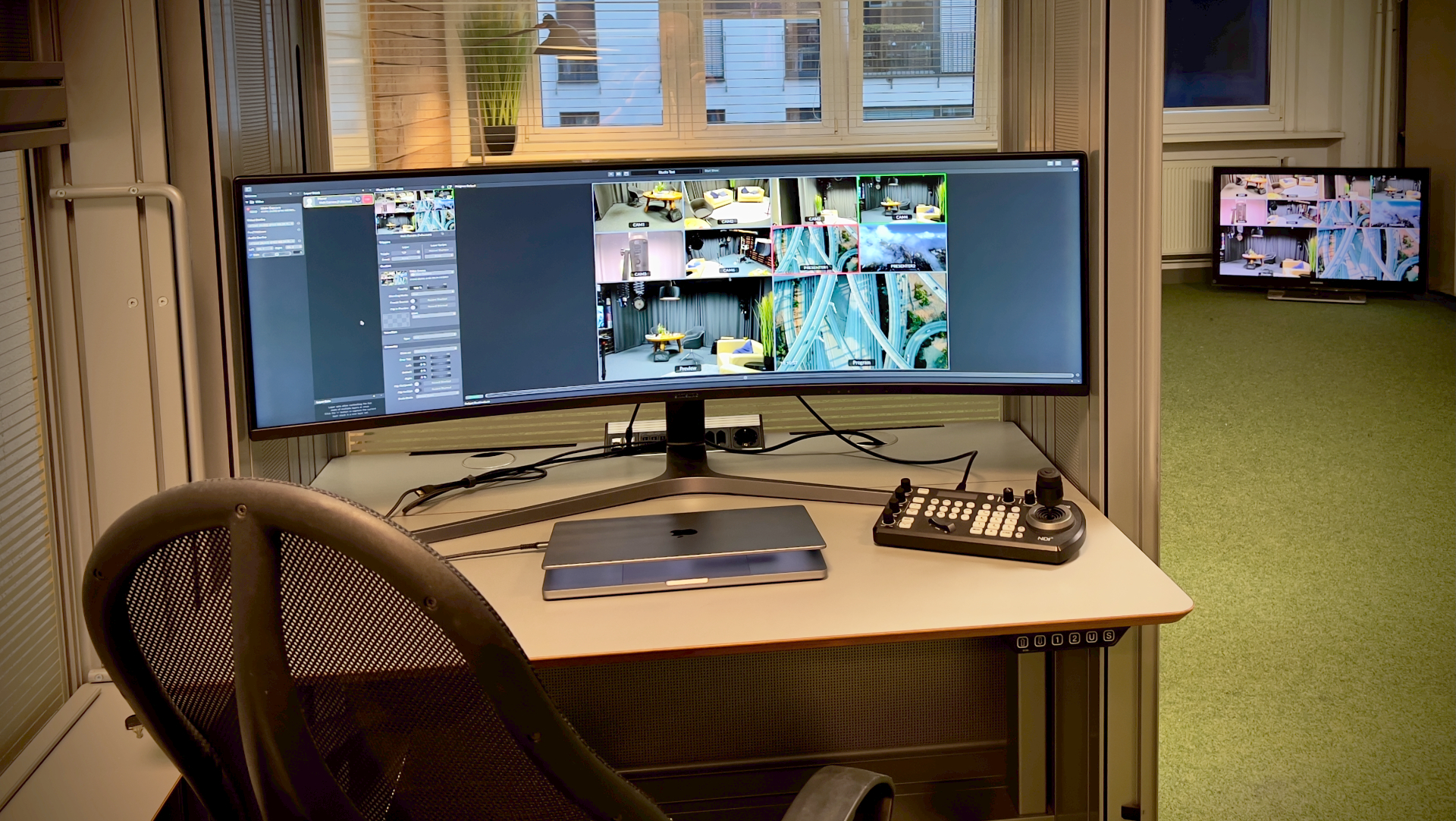 Regieplatz im Prismeo Studio mit Ultrawide-Monitor, Multiview, NDI-Controller und MacBook