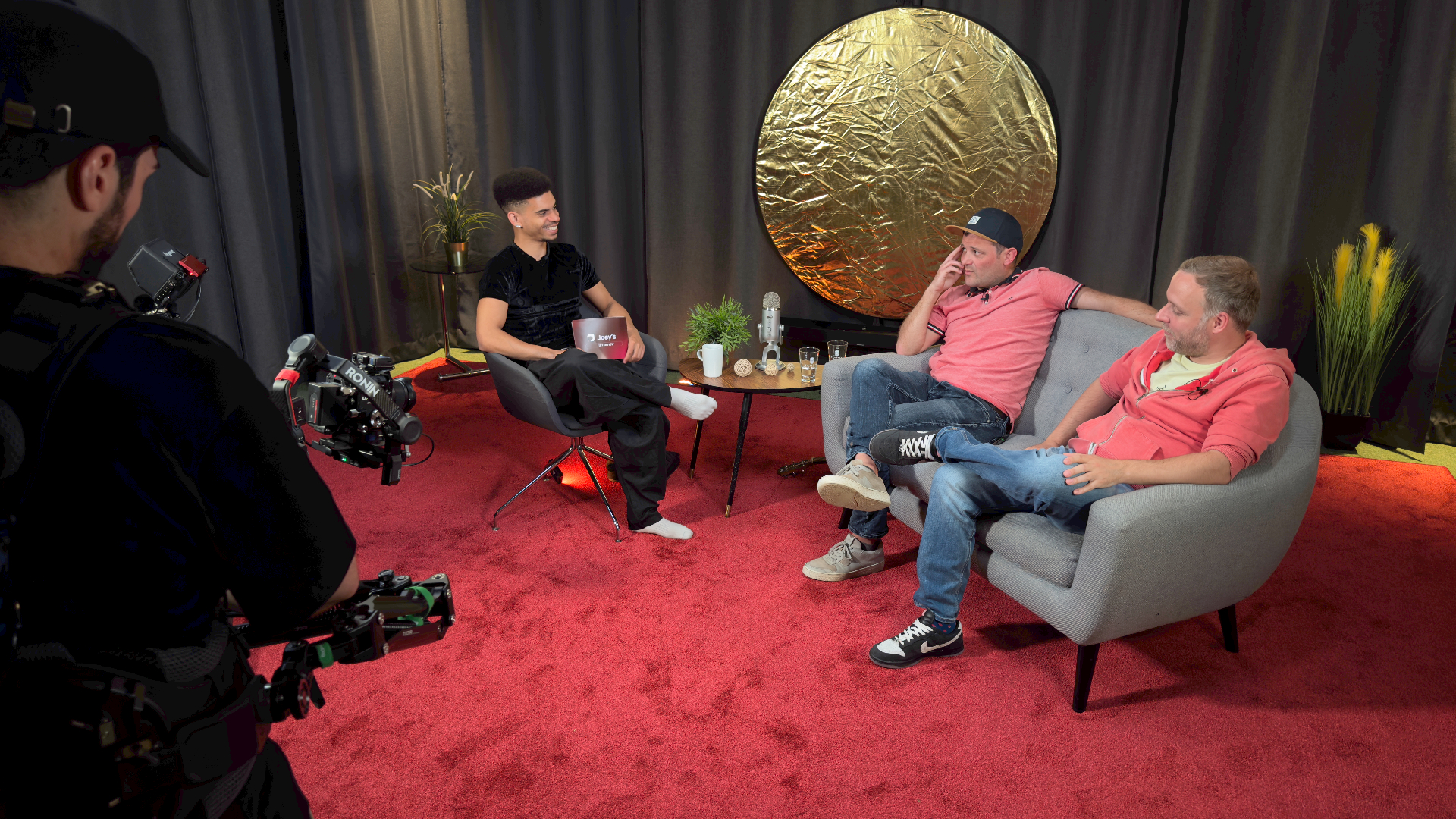 Aufzeichnung eines Videoformats im Prismeo Studio mit Kameraoperator und Sofa-Setup
