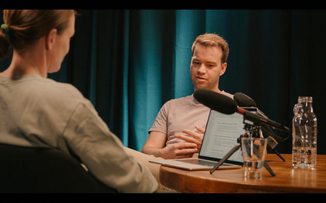 Naher Gesprächsmoment bei einer Podcastproduktion im Prismeo Studio mit Mikrofonen und Laptop