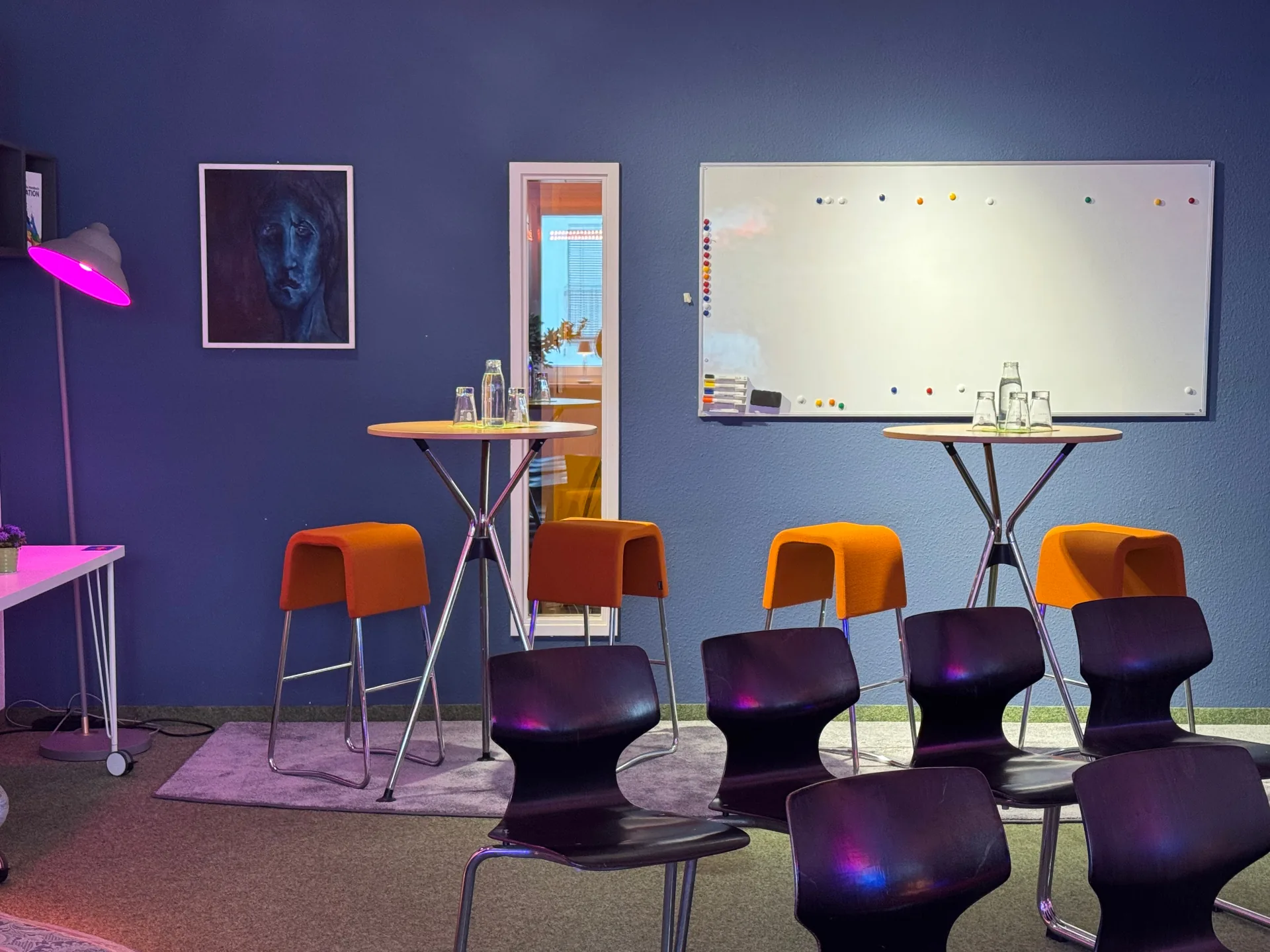 Vorbereiteter Trainingsraum im Prismeo LAB mit Stuhlreihe, Stehtischen und Whiteboard vor Beginn der Session