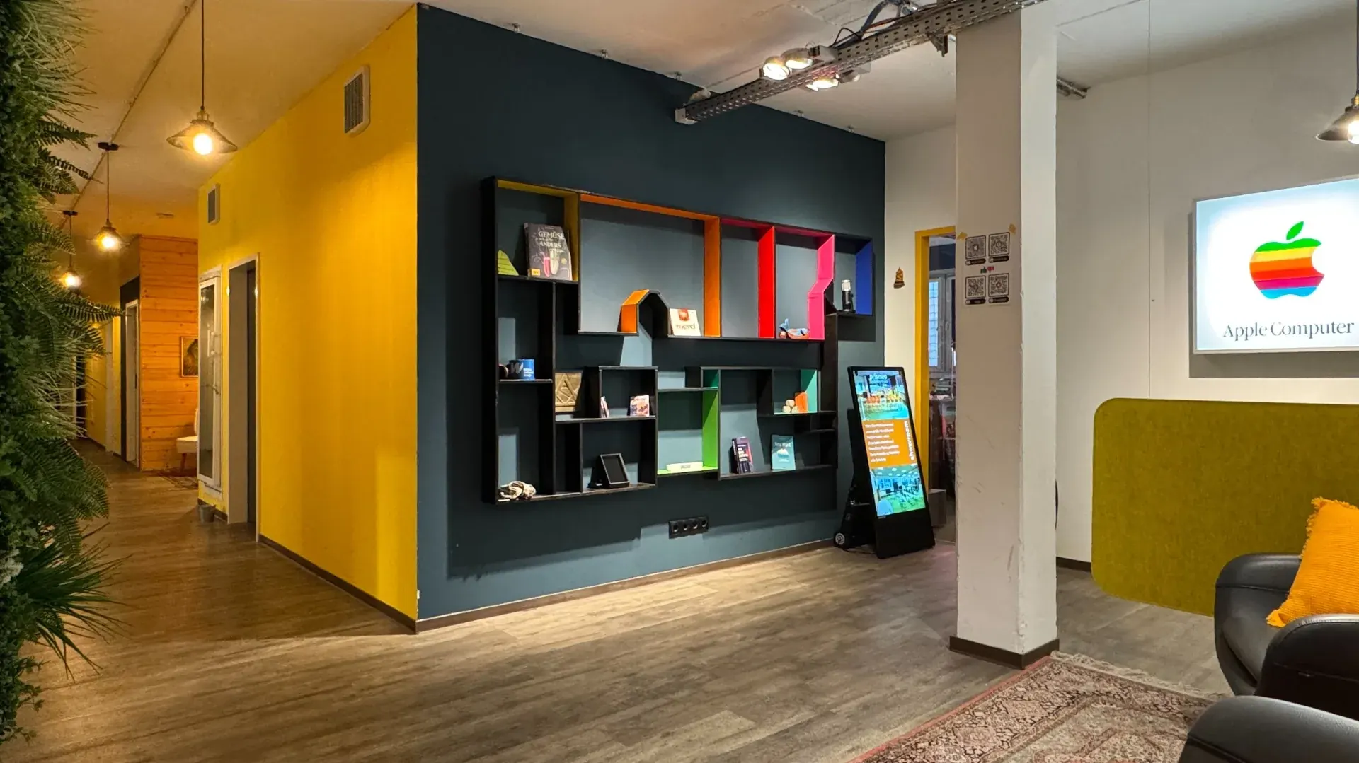 Foyer des Prismeo LAB mit farbiger Wandgestaltung, Regal und Lounge-Bereich