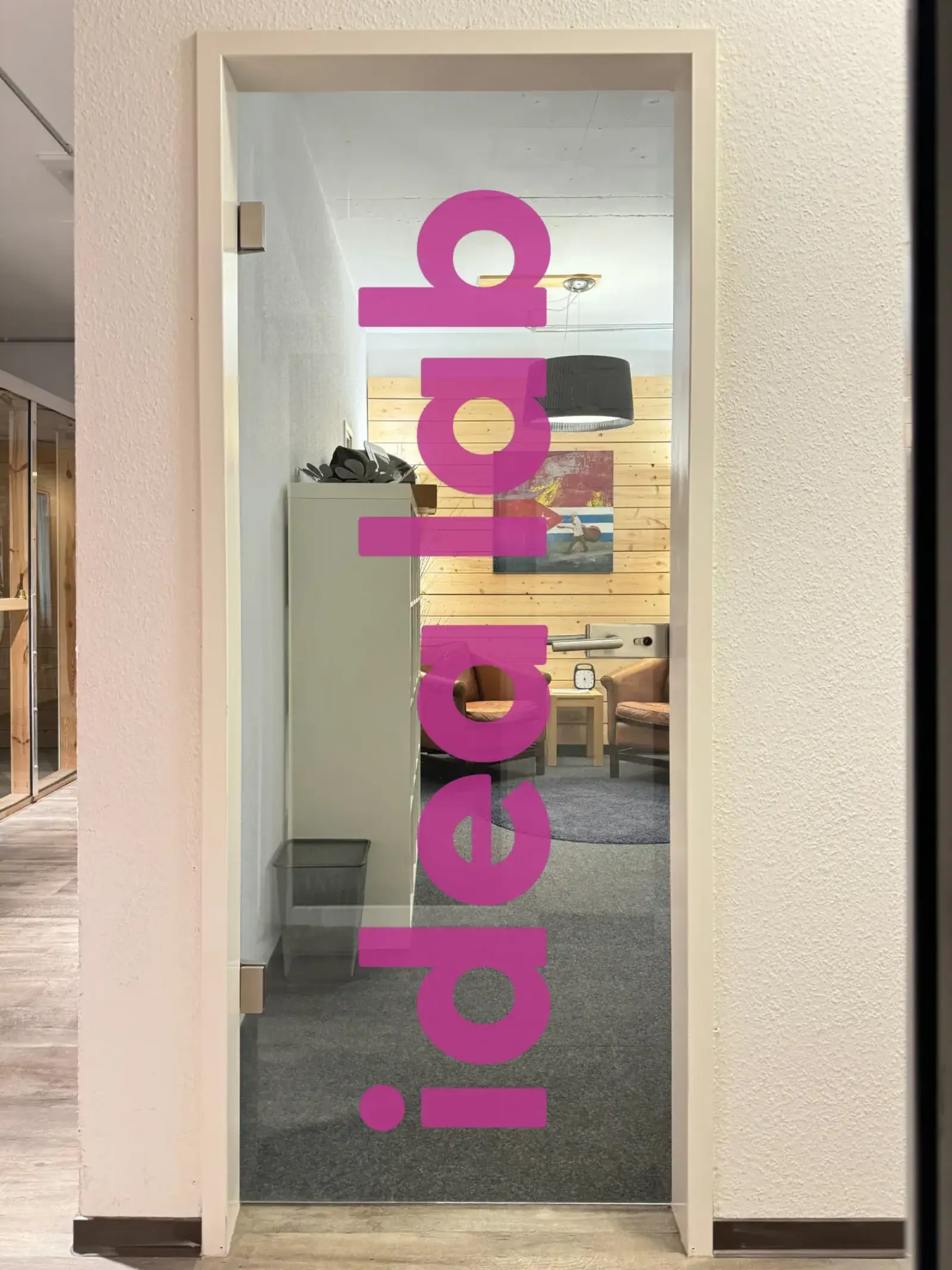 Idealab – Eingang zum Idealab mit pinkfarbenem idealab-Schriftzug auf der Glastür