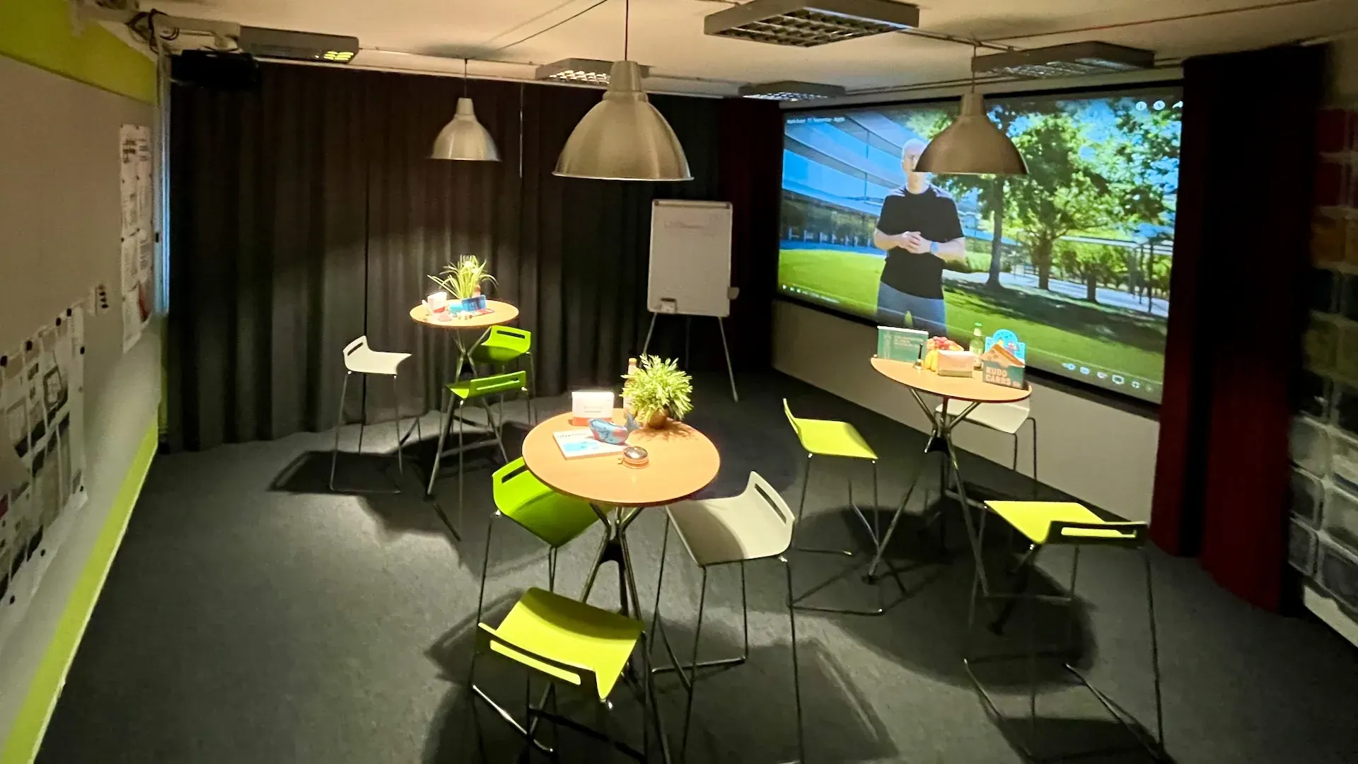 Idealab – Idealab im Prismeo LAB Hamburg HafenCity – Workshop-Setup mit Stehtischen, grünen Hockern und Großbildprojektion