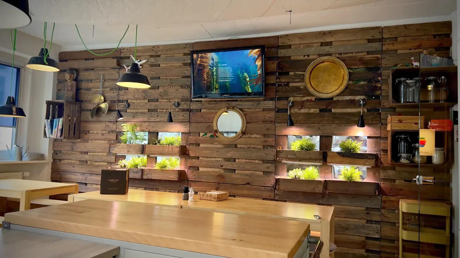Kitchen – Holztisch der Kitchen mit Display, Buddha-Figur und Kaffee – Pause mit Atmosphäre