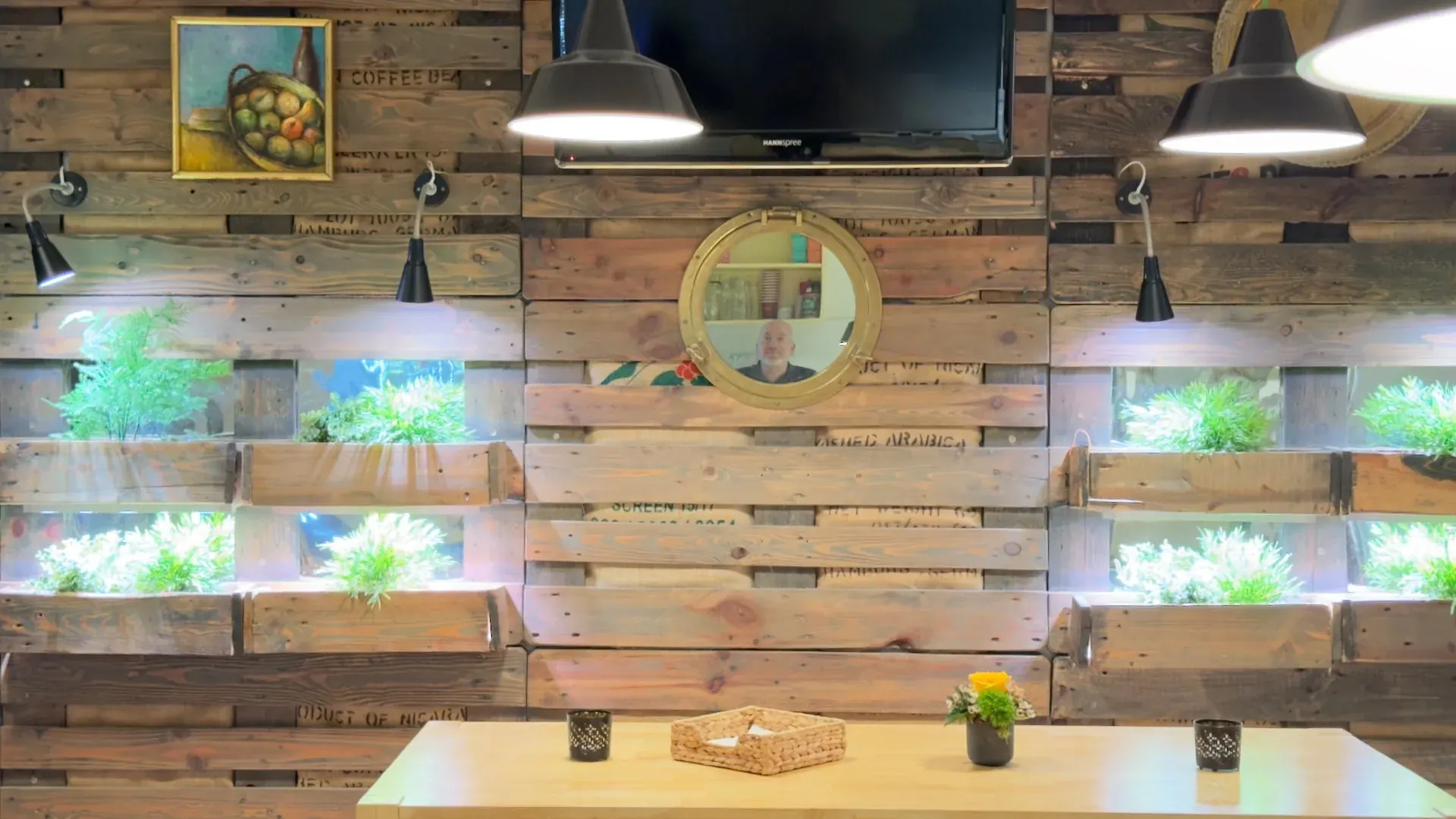 Kitchen – Detail der Palettenwand mit Bullaugen-Spiegel und beleuchteten Pflanzenboxen