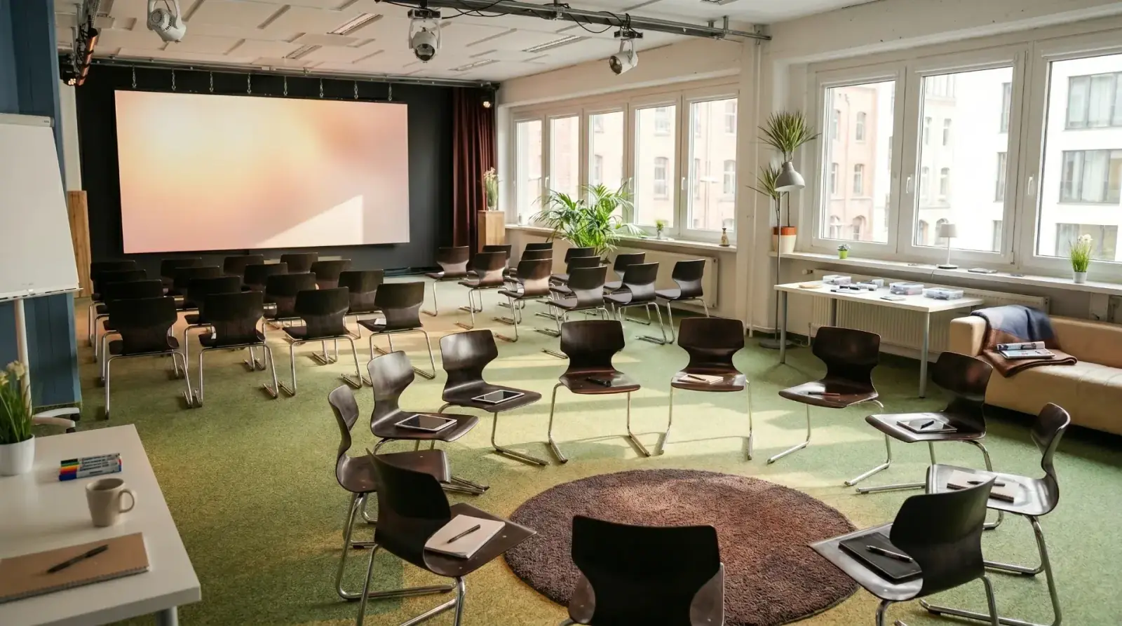Showroom – Showroom in Workshop-Bestuhlung mit Stuhlkreis, Leinwand und Tageslicht
