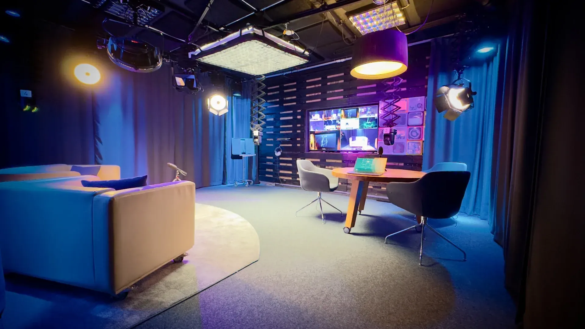 Studio – Studio-Set mit Talk-Tisch, Sofa und Wand aus Holzpaletten mit Multi-Screen-Display