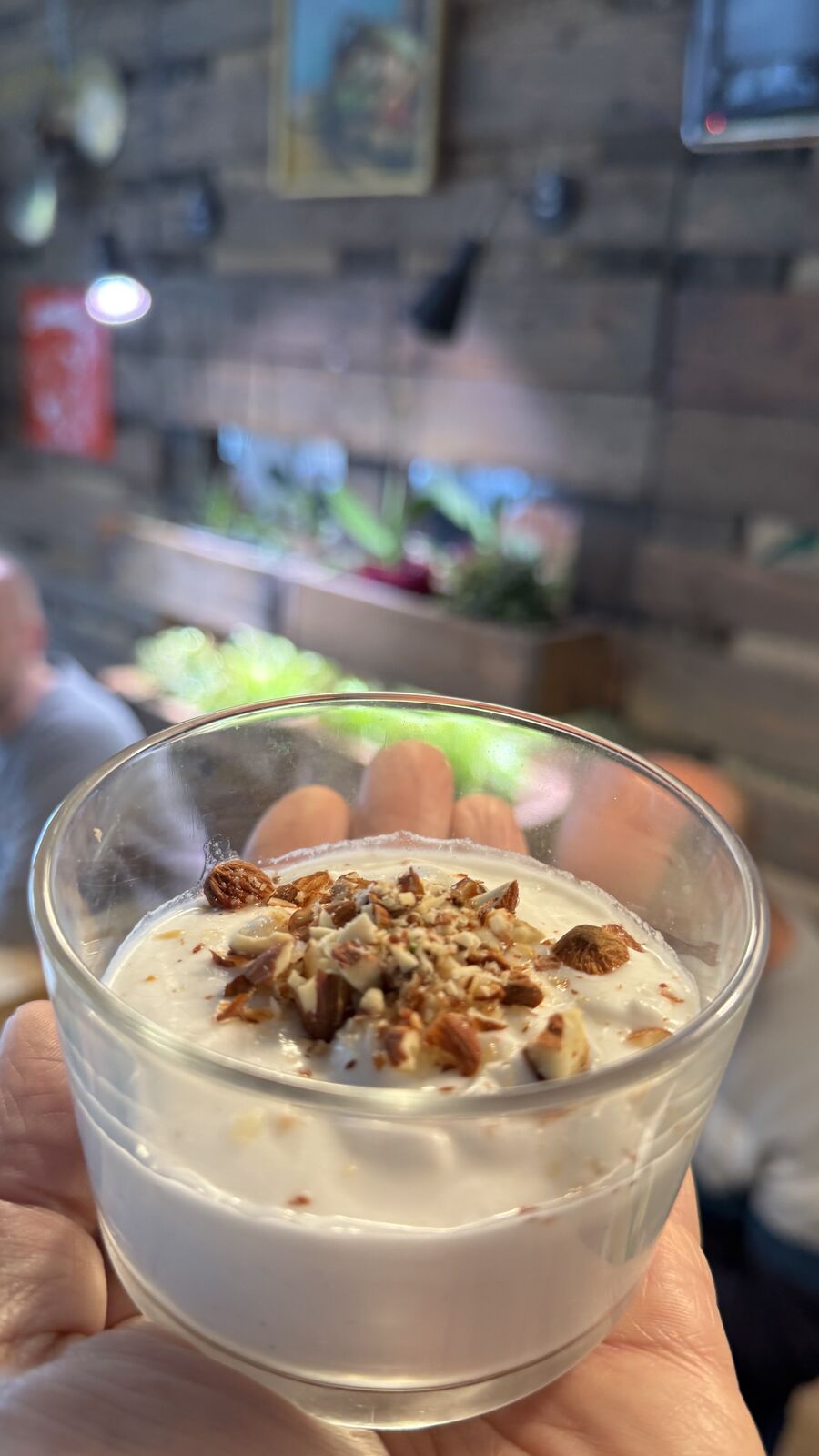Dessert im Glas, garniert mit Nüssen und Rosinen.