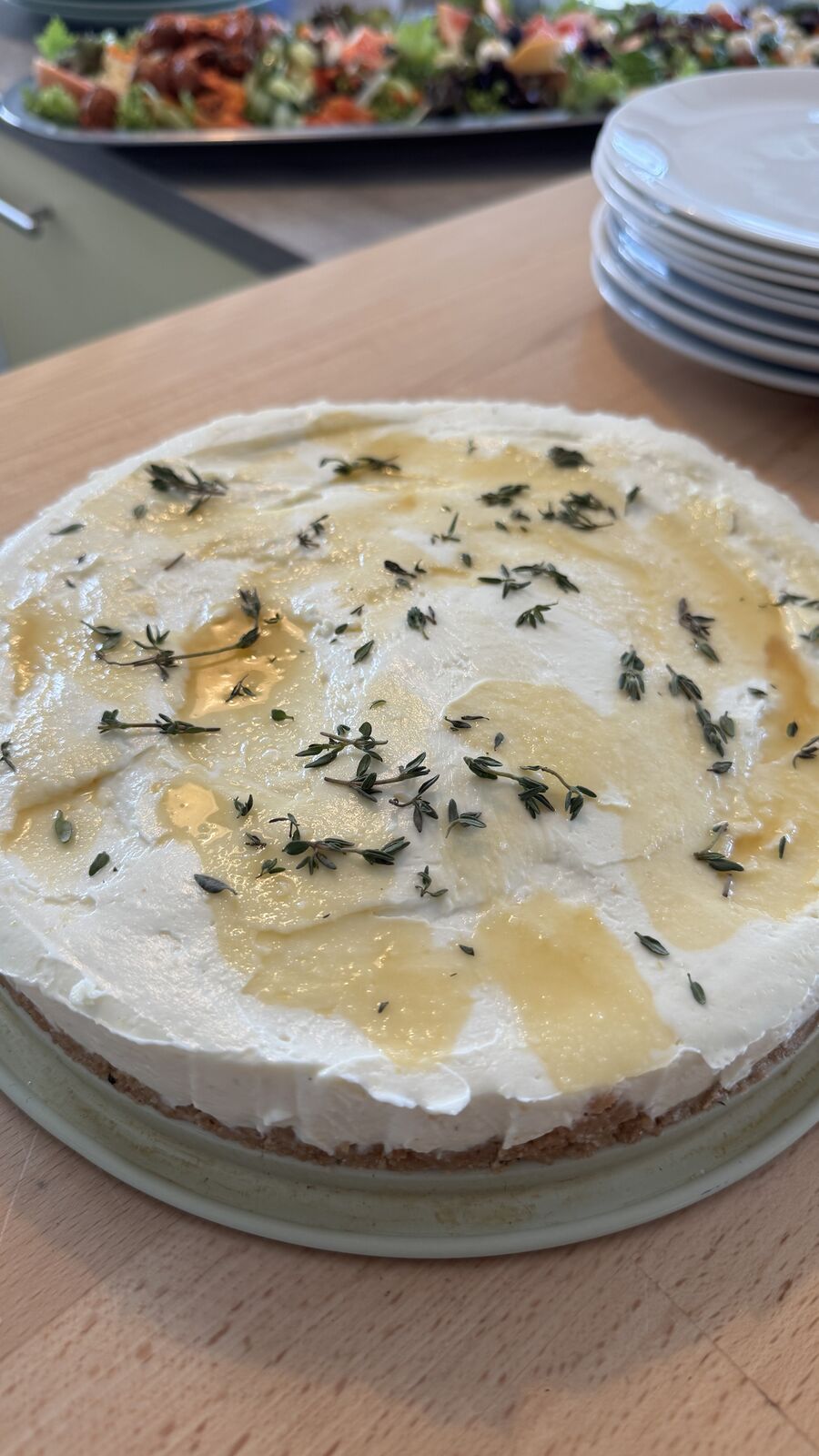Runder herzhafter Kuchen mit Frischkäse, Olivenöl und Thymian bei einem Lunch-Buffet.
