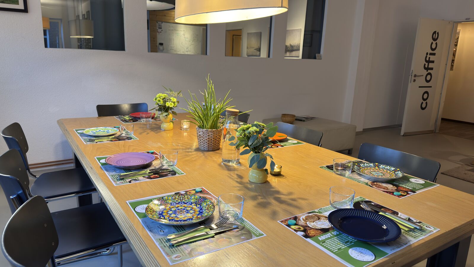 Ein gedeckter Tisch in einem Raum mit langer Holztafel und modernem Ambiente.