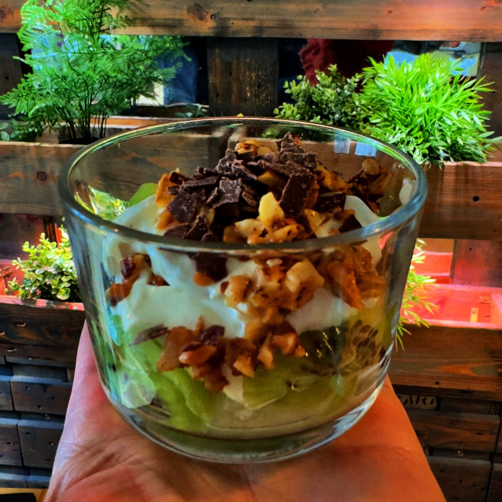 Dessert im Glas mit Kiwi, Joghurt oder Creme, Nüssen und Schokoladenstücken.
