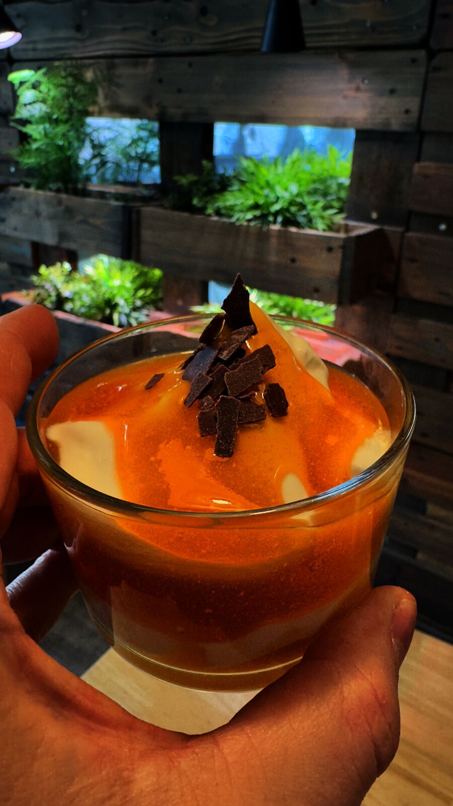 Dessert aus Creme, Orangensoße und Schokoladensplittern im Glas