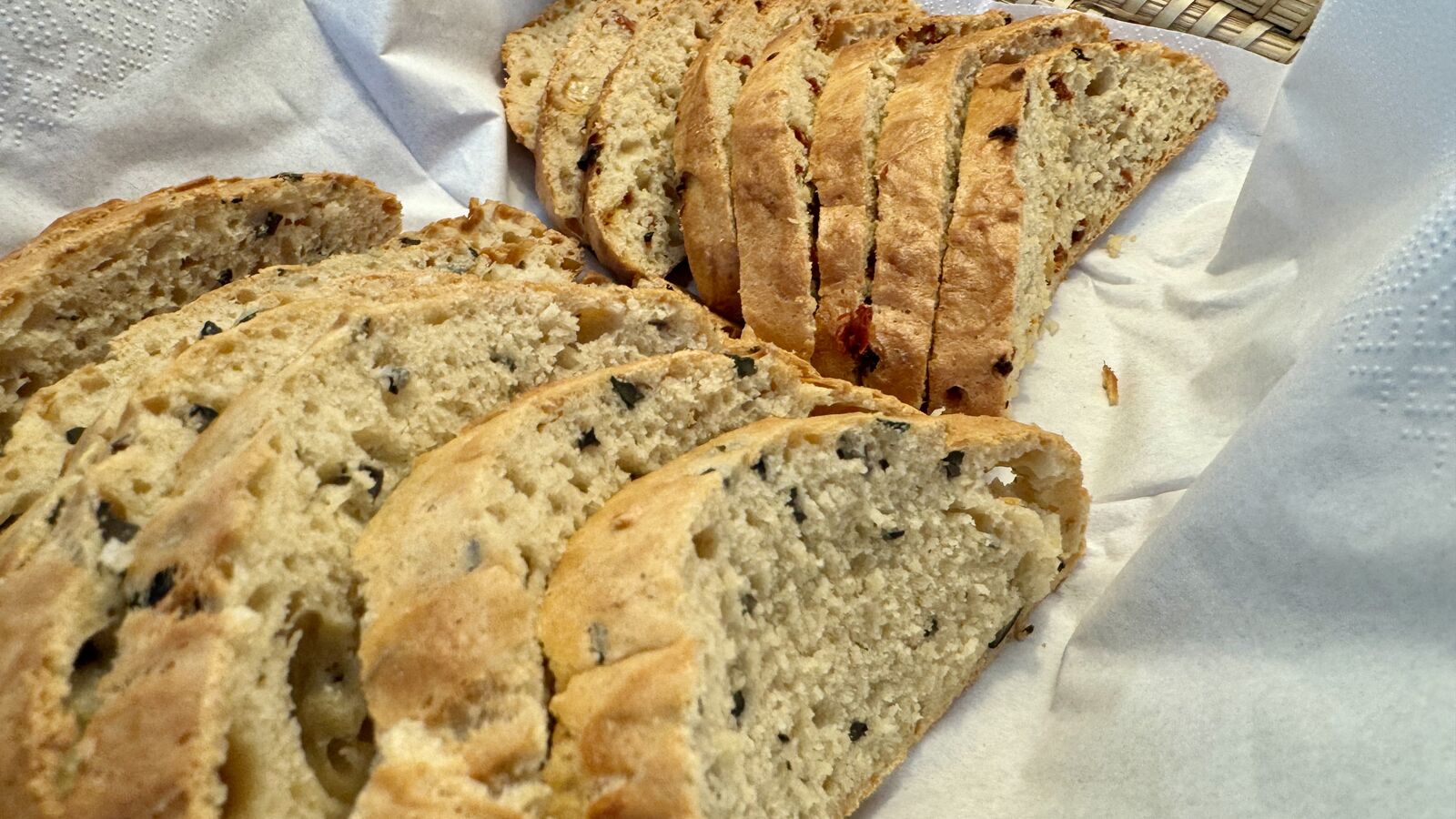 Geschnittenes Brot mit Oliven und getrockneten Tomaten.