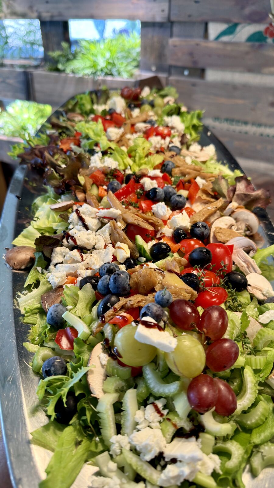 Bunter Salat mit Blattsalat, Feta, Trauben, Heidelbeeren und Balsamico-Dressing.