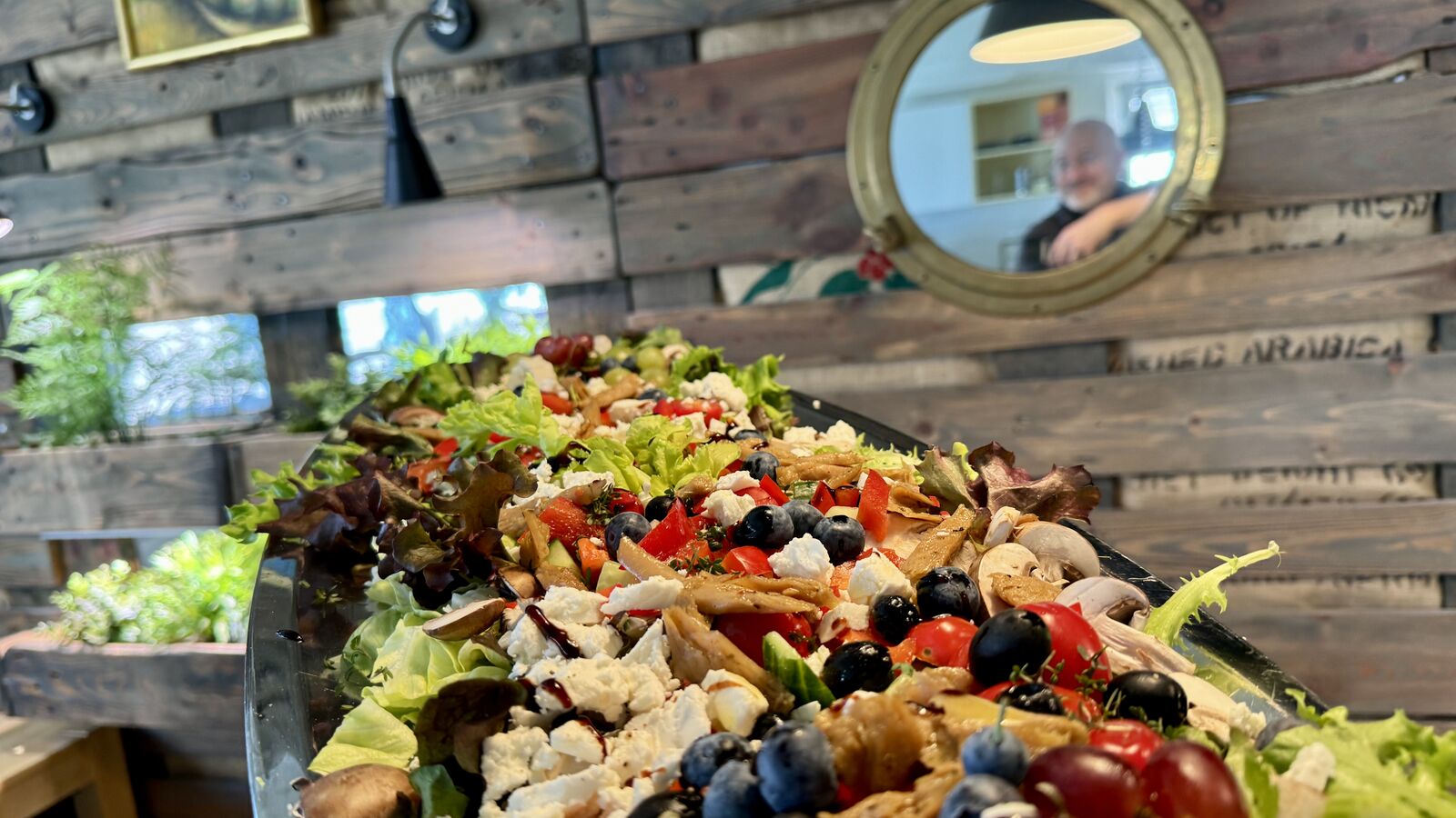Buntes Salatbuffet mit Feta, Blaubeeren und Hühnchen auf Holztheke