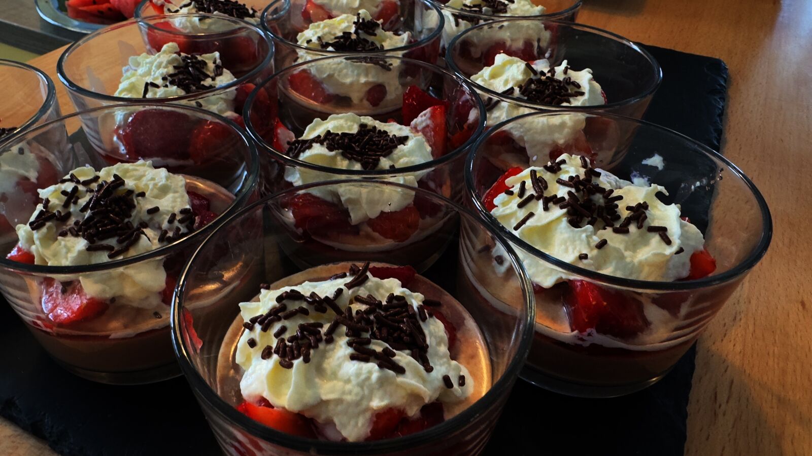 Dessertgläser mit Erdbeeren, Sahne und Schokostreuseln