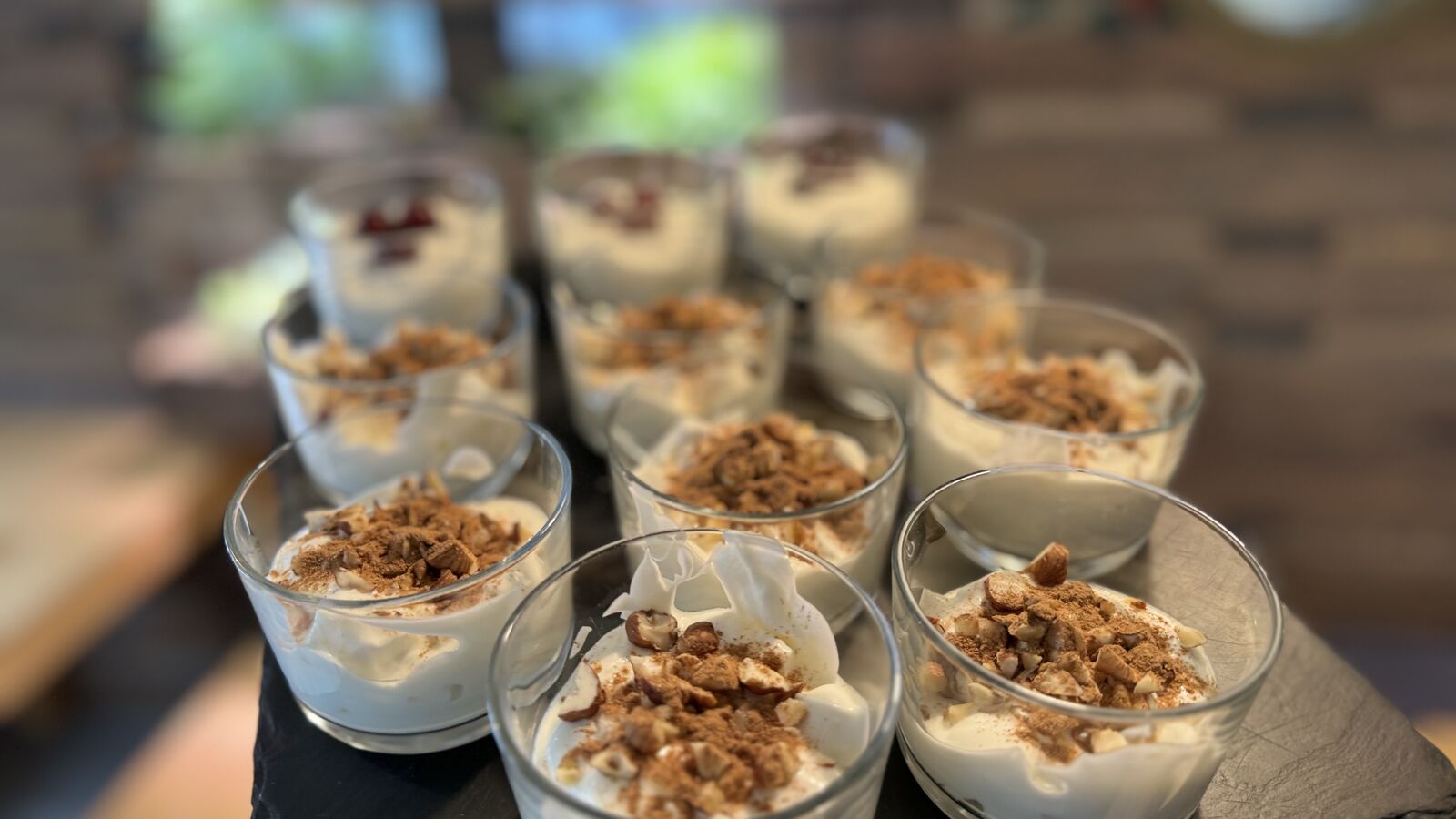 Dessertgläser mit Creme, gehackten Nüssen und Zimt