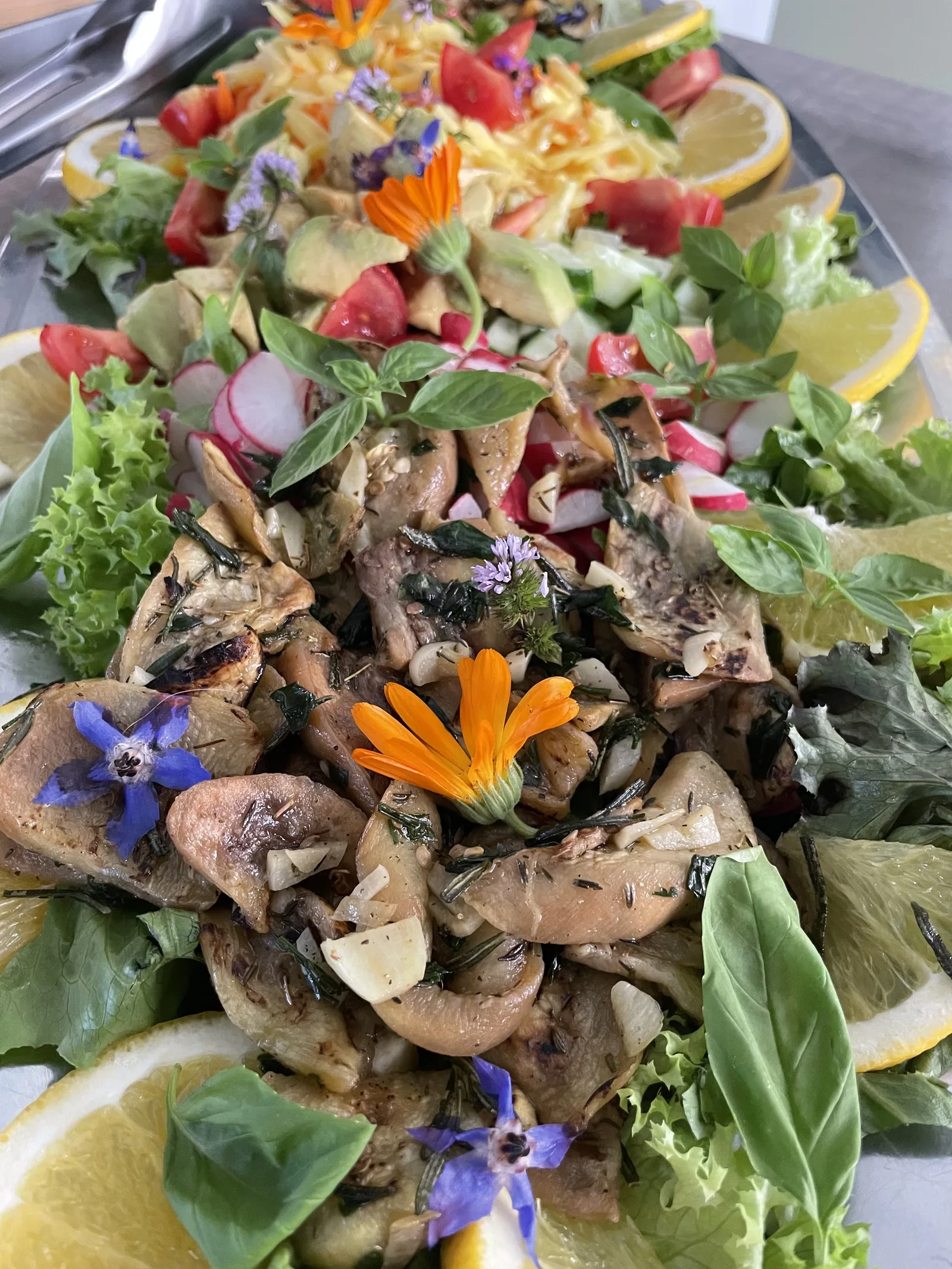 Salatplatte mit essbaren Blüten und Tapas